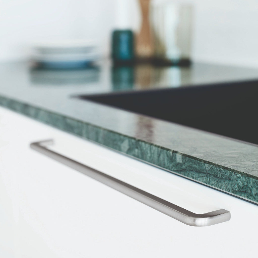 Inox look Furnipart Compact cabinet handle, 320 mm, on a white drawer under a green marble countertop.