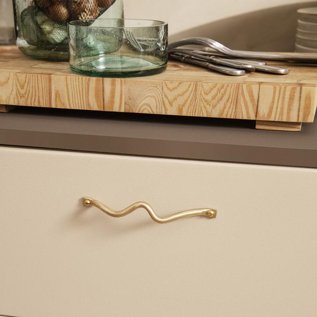 Curvature handles, brass finish, drawer pull, horizontally mounted.