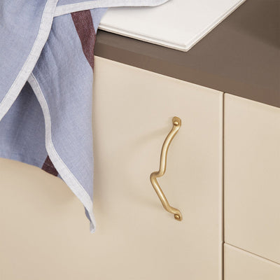 Curvature handles, brass finish, cabinet pull, vertically mounted.