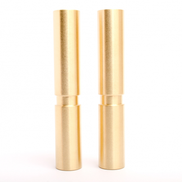 A pair of Baccman Berglund Hey Legs lipsticks in gold on a white background.