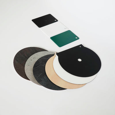 A pile of Dan Dryer Finish Sample discs in different colors on a white surface.