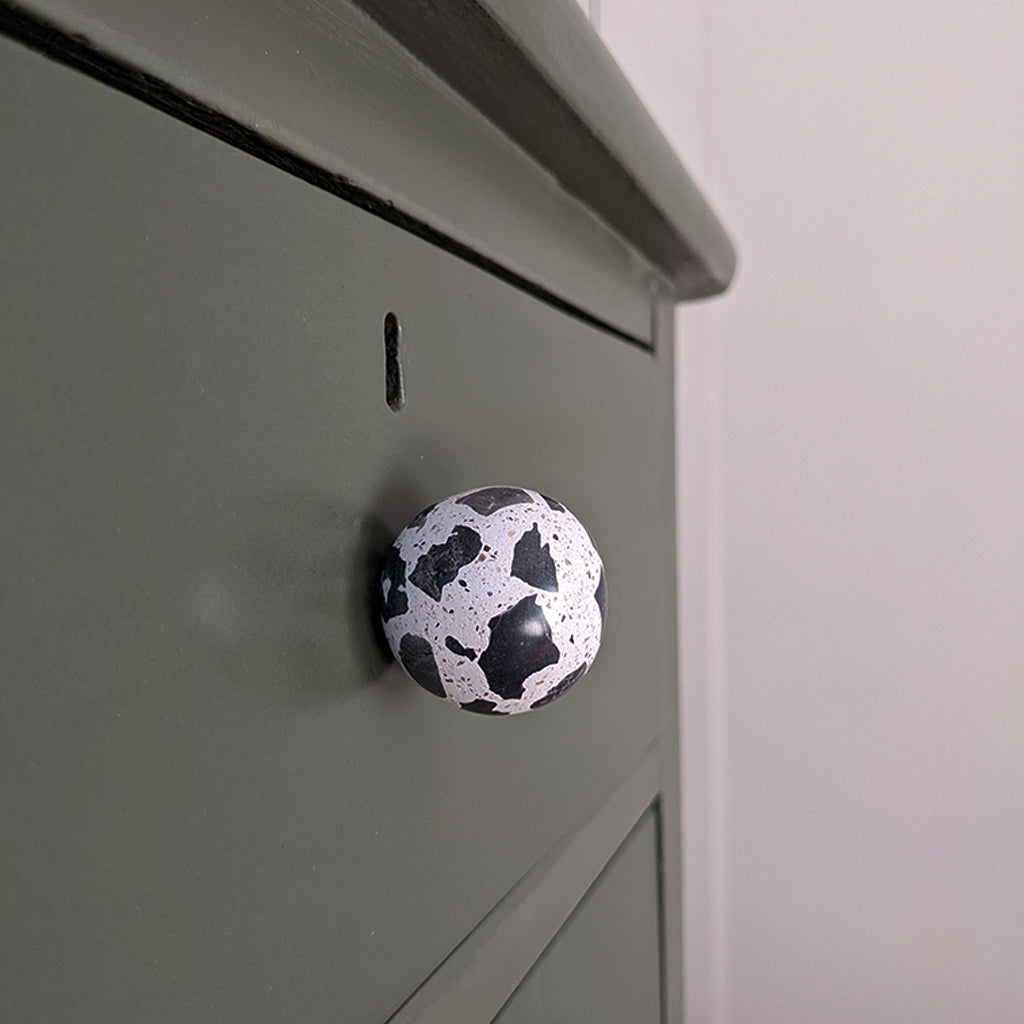 A Urbi et Orbi Demenico Sphere Knobs on a green cabinet.