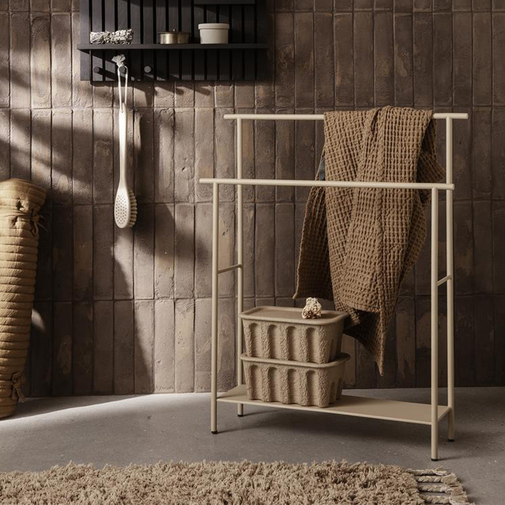 A bathroom with a Ferm Living Dora Towel Stand and shelf.