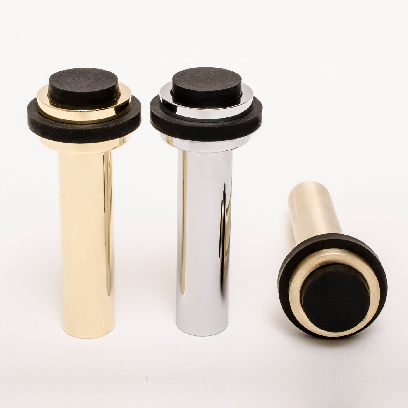 A set of three Baccman Berglund Dot Door Stop knobs in black and gold.