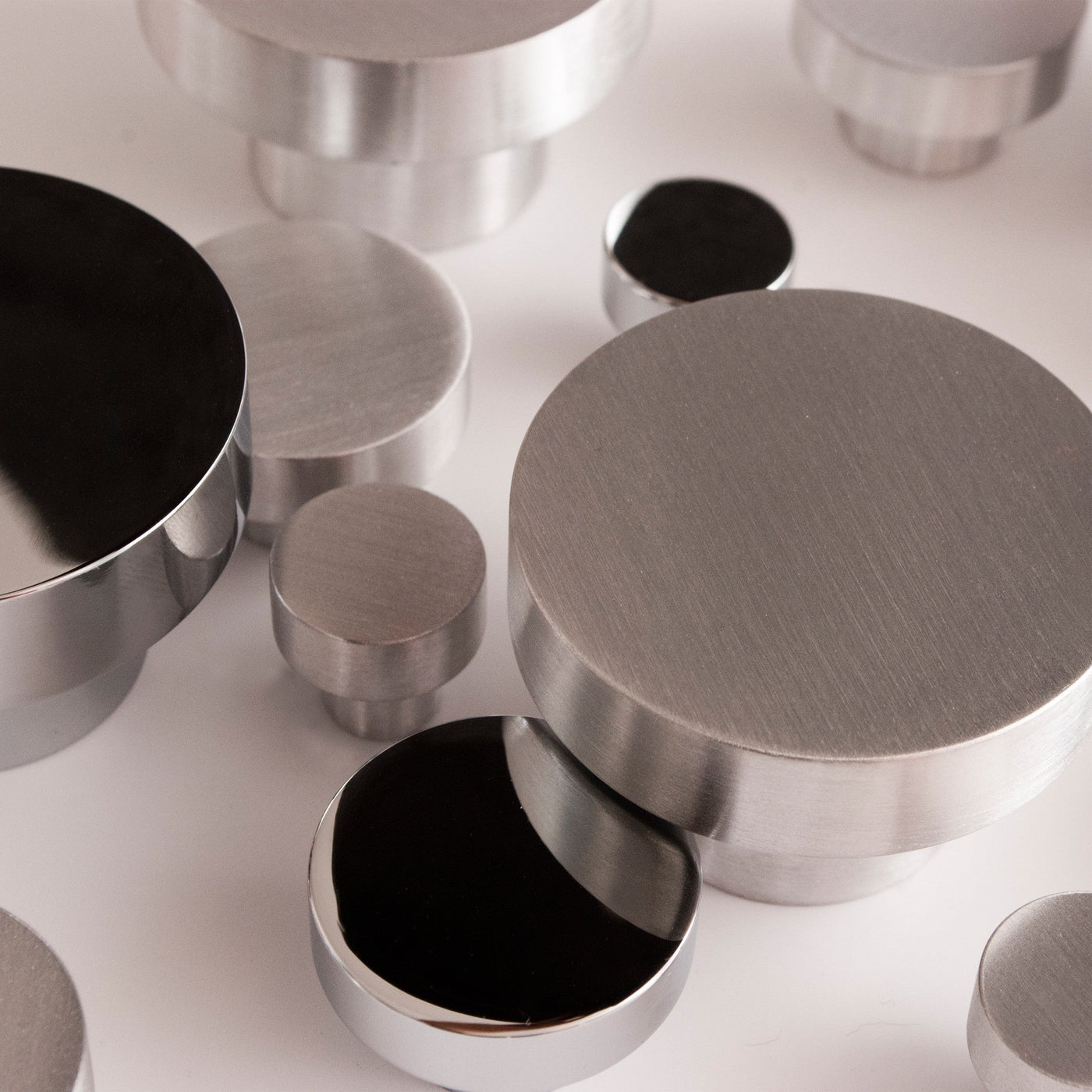 A close up of several Baccman Berglund Dot Knobs on a white surface.