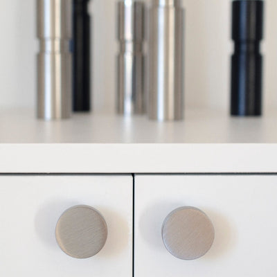 A close up of a white cabinet with Baccman Berglund Dot Knobs.