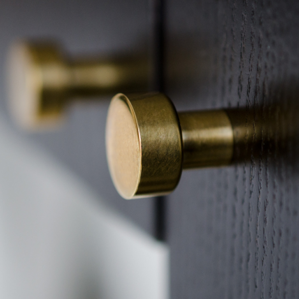 A close up of a Baccman Berglund Dot Knob on a door.