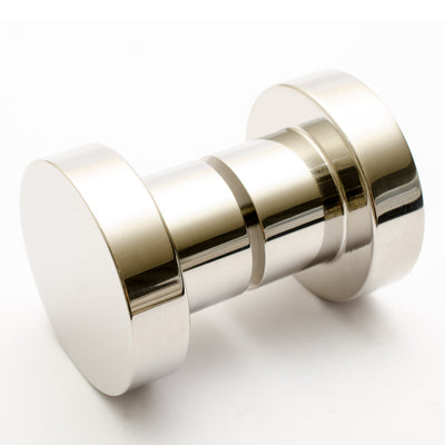 A close up of a Baccman Berglund Dot Shower Door Knob on a white surface.