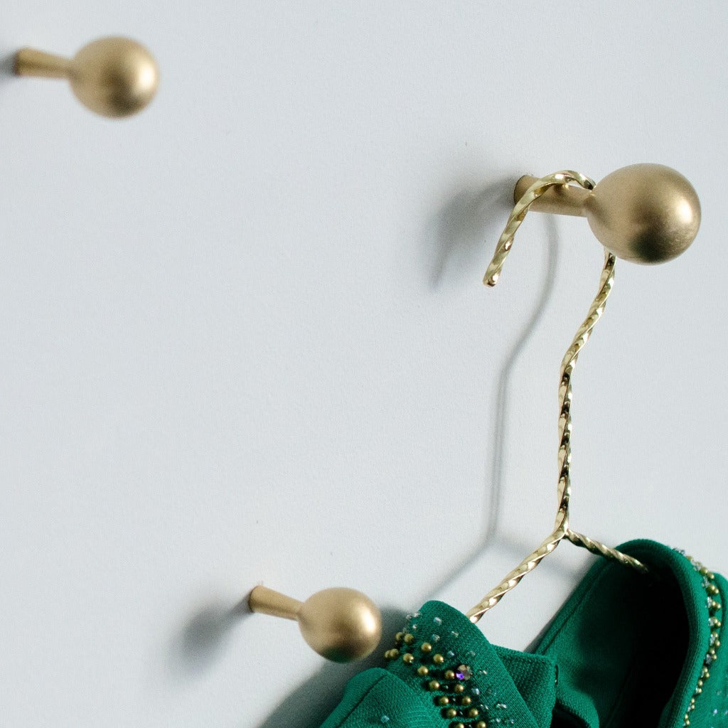 A pair of green Drop Hook shoes from Baccman Berglund hanging from a hook.