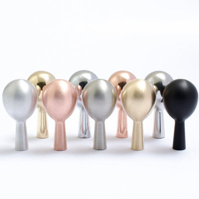 A row of Baccman Berglund Drop Hook metallic and black knobs on a white background.