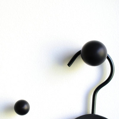 A pair of black Baccman Berglund Drop Knob Hooks hanging from a hook.