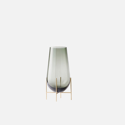 Small clear glass vase sitting on beautiful bronze legs.