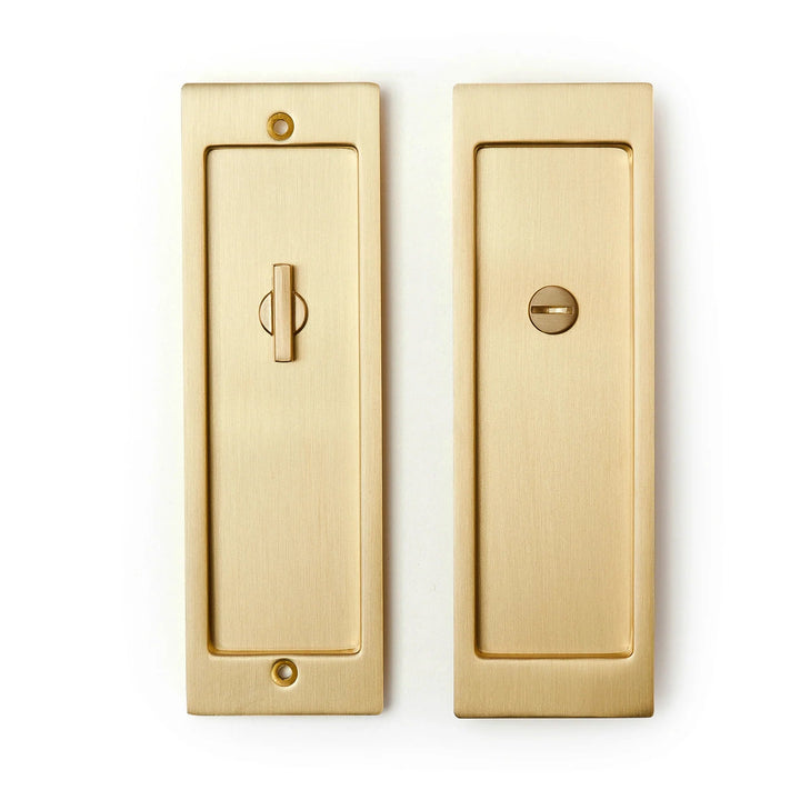 A pair of AHI Explore Pocket Door Set Privacy brass door handles on a white background.