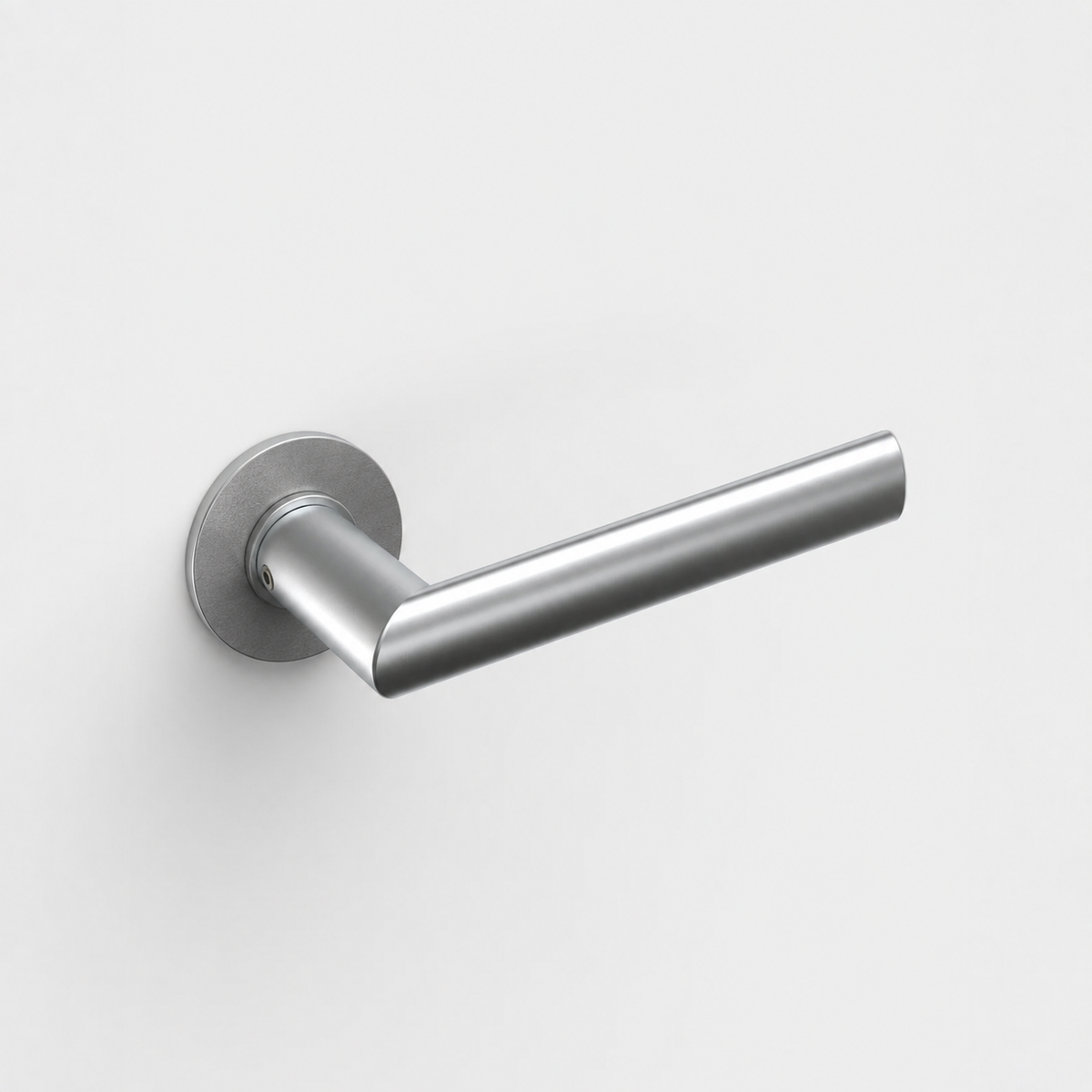FSB 1108 stainless steel door lever with a round neck and ergonomic mitred grip on a circular rose against a white wall.