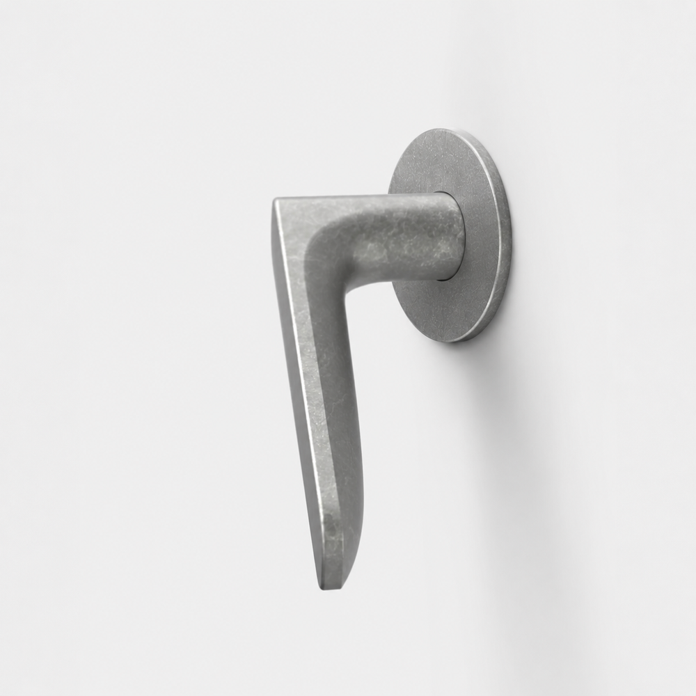FSB 1289 matte silver door lever with a flat front and convex grip on a circular rose against a white background.