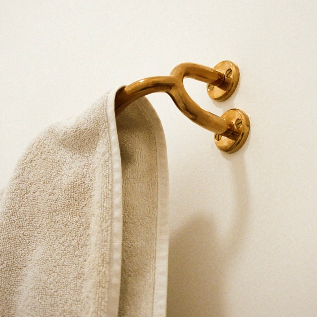 Brass Maha Alavi Fauna towel bar with a towel.