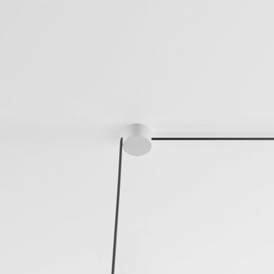A black and white photo of an Anony Form Linear Suspension ceiling light.