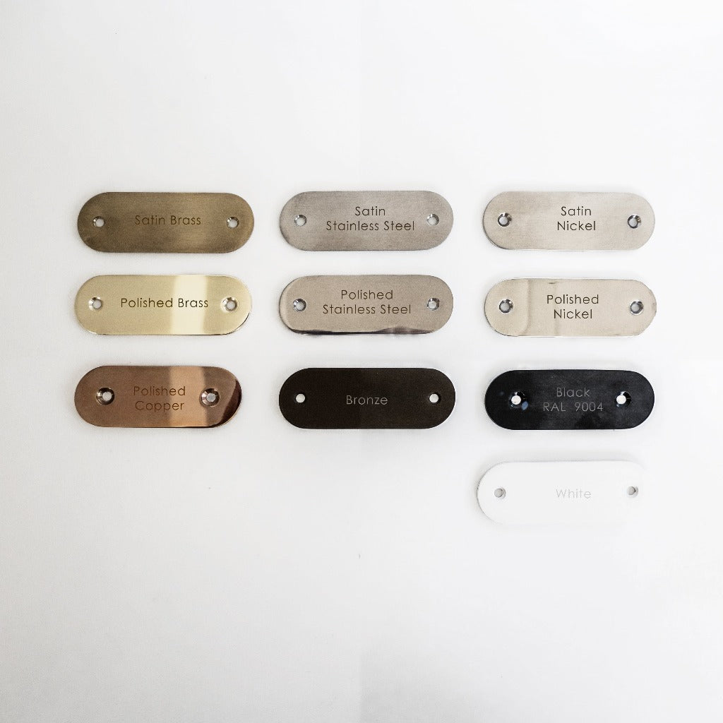 A group of Formani metal tags on a white surface.