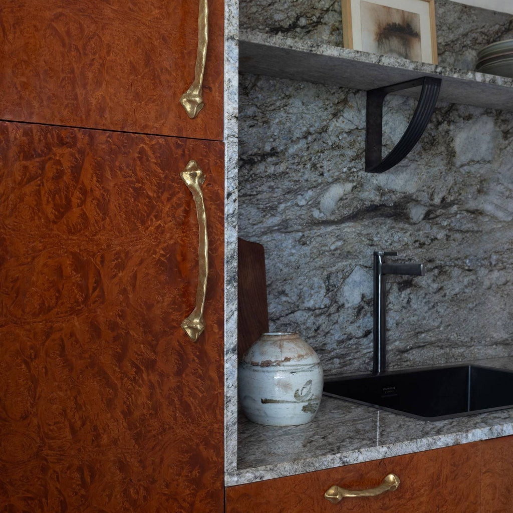 Large Mi & Gei Forme No. 41 cabinet pull on a stone-clad kitchen island in champagne bronze.