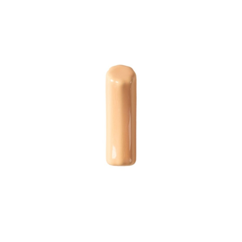A pale coral coloured ceramic wall hook or pull arranged vertically and shaped like a closed ended tube with a bone like smooth texture running along the edges.