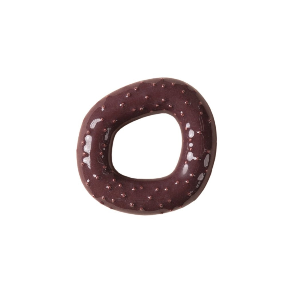 A brown ceramic wall hook or pull that is shaped like an irregularly round doughnut with a spotty texture on top against a white background.