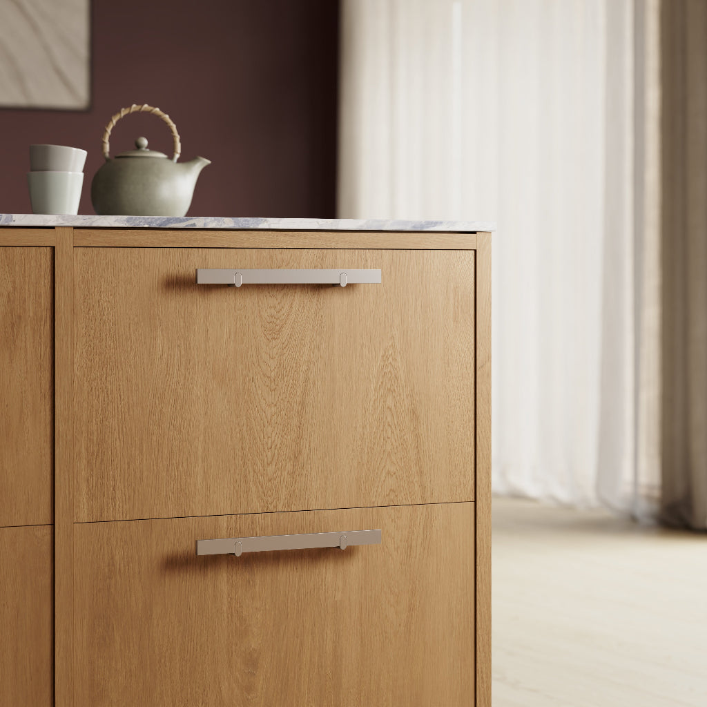 Metal cabinet pulls mounted on light wood drawers