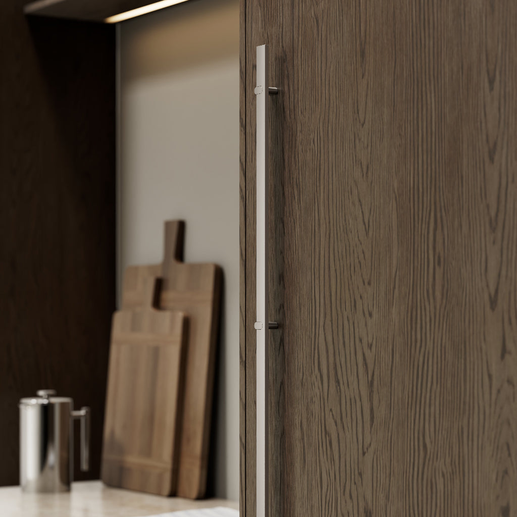 Metal cabinet pull mounted on dark wood cabinetry
