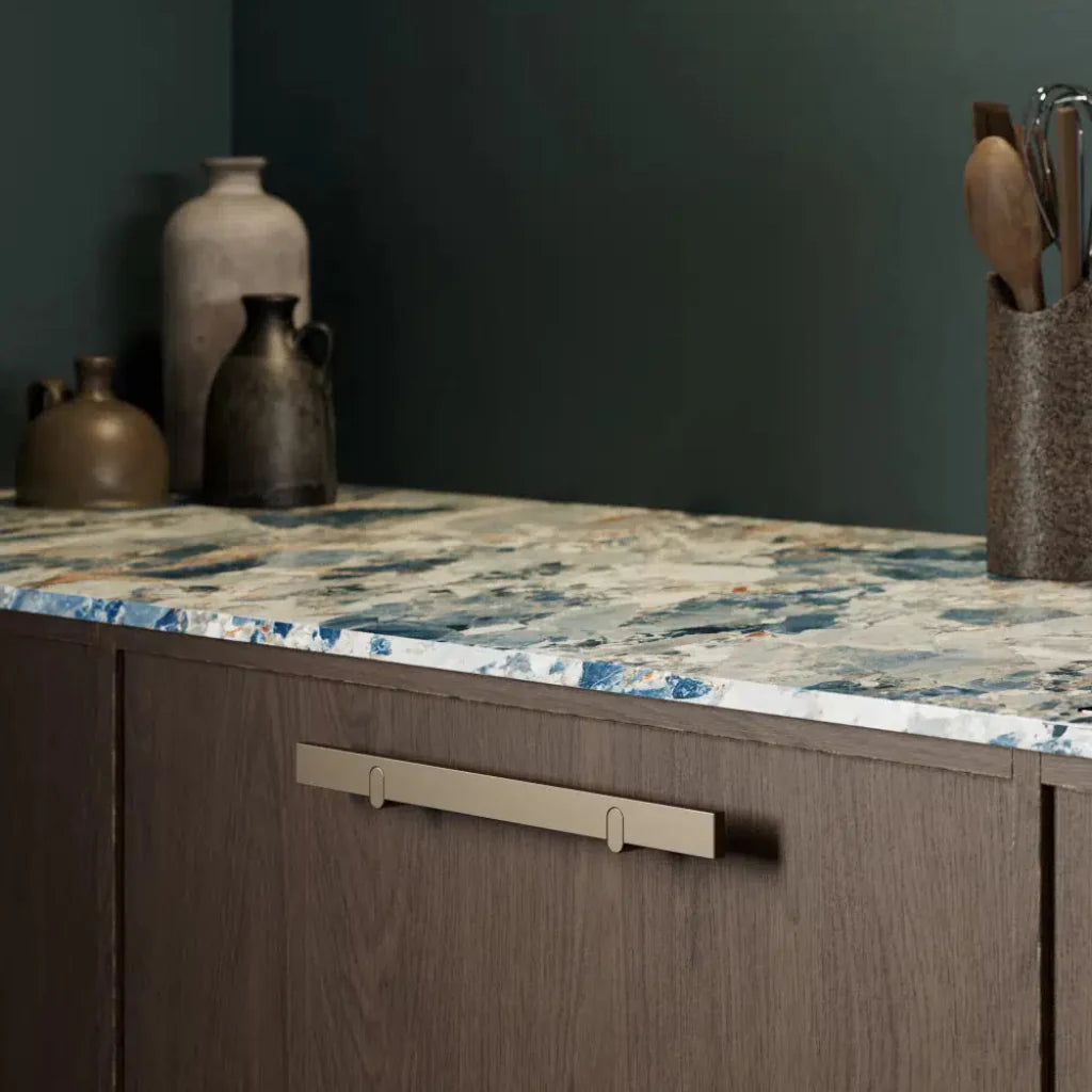 Metal cabinet pull mounted on dark wood drawer