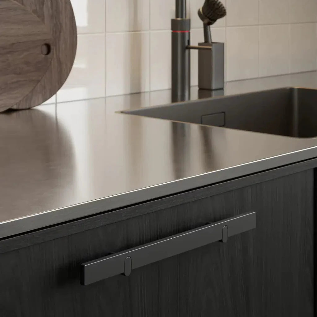 Metal cabinet pull mounted on dark wood drawer