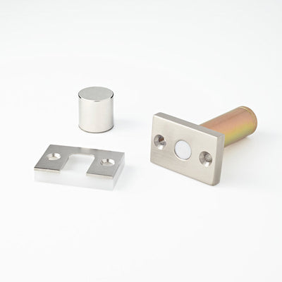 A couple of Ghostop Concealed Door Stop GS200 parts sitting on top of a white surface.