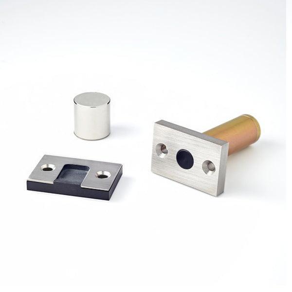 A couple of Ghostop Concealed Door Stops GS200 sitting on top of a white surface.