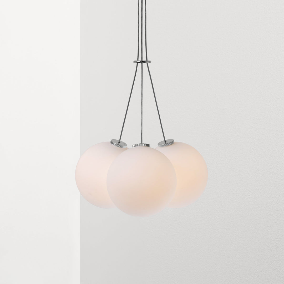 Three Anony Glass 120R Pendant fixtures hanging from a ceiling fixture.