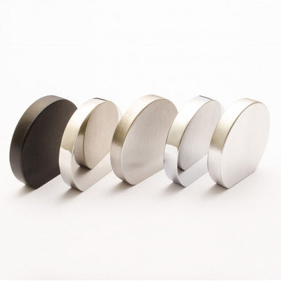 A row of different sizes of Baccman Berglund Globe Knob magnets on a white surface.