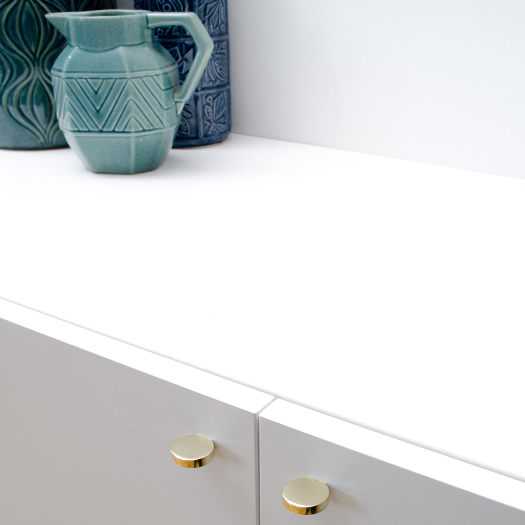 A Baccman Berglund Globe Knob sitting on top of a white dresser.