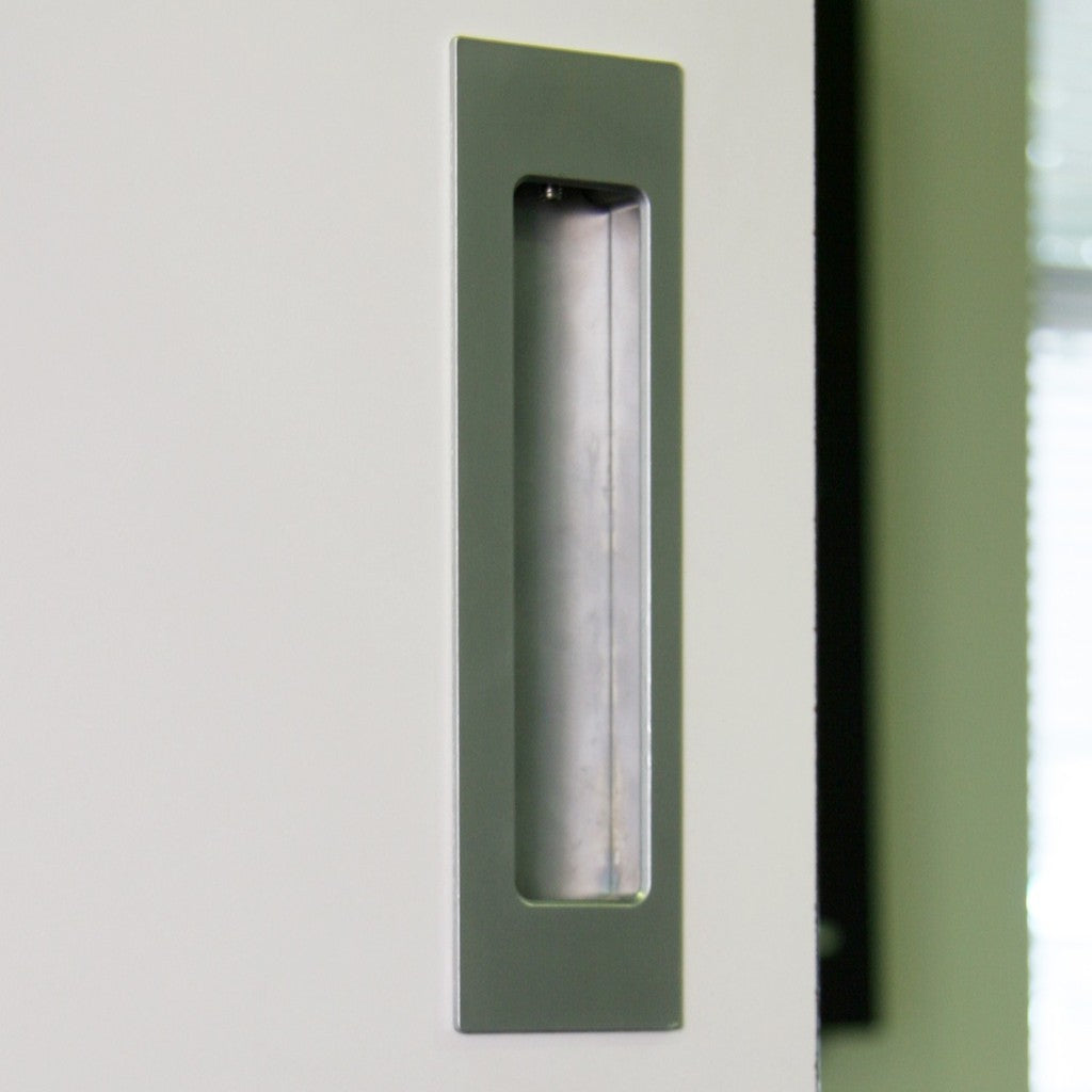 Close-up of a satin HB 675 bi-fold flush pull recessed into a grey-green door.