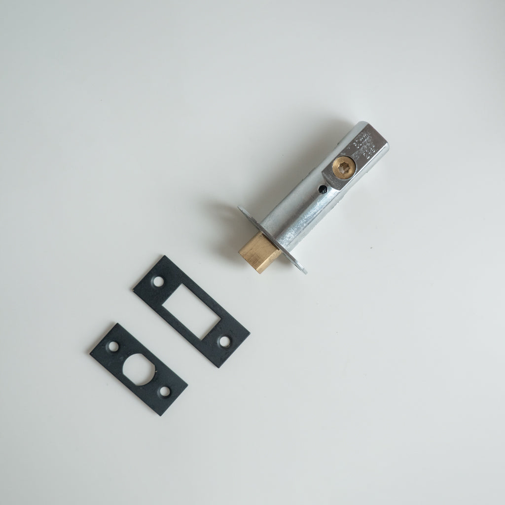 A couple of Baton Heavy Duty Mortise Bolt LT783MB / LT786MB metal parts sitting on top of a white table.