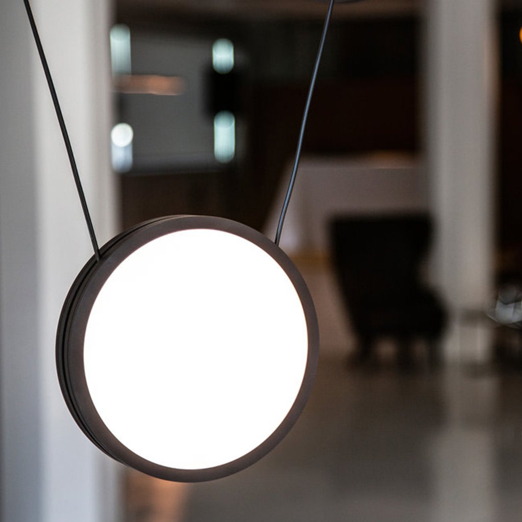 Matte black pendant lights balanced on individual wires