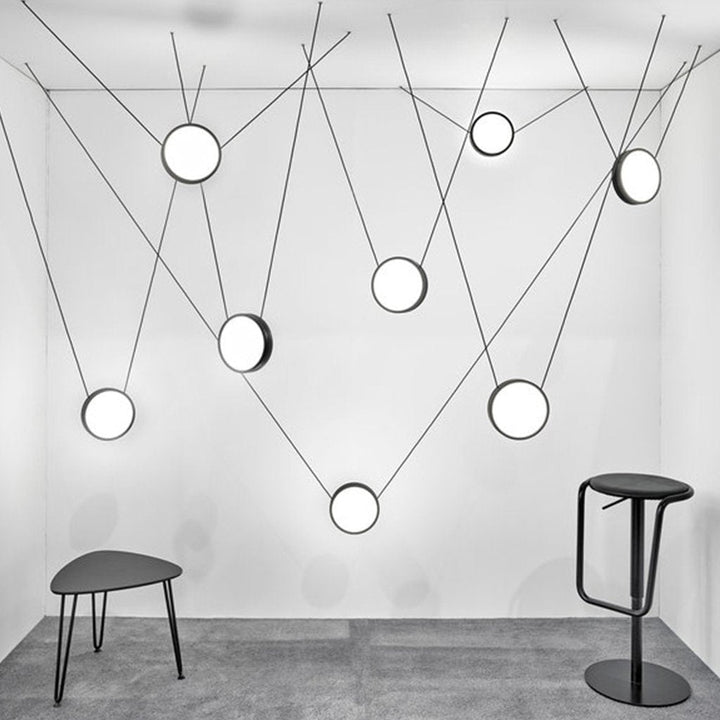 Matte black pendant lights balanced on individual wires