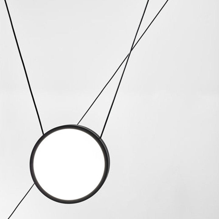 Matte black pendant lights balanced on individual wires