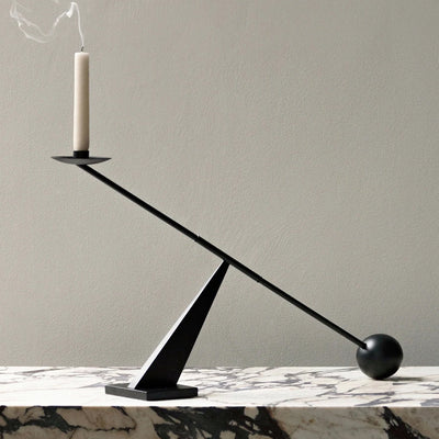 Black Interconnect Candle Holder from Menu styled on textured marble table against grey wall.