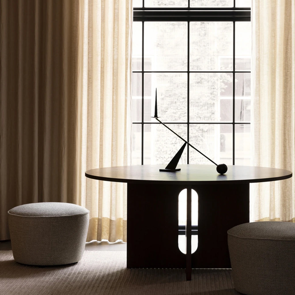 Interconnect Candle Holder backlit on round dining room table showcasing the sculptural elements of the item.