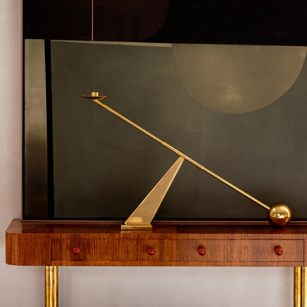 Interconnect Candle Holder in brass styled on wooden console table.