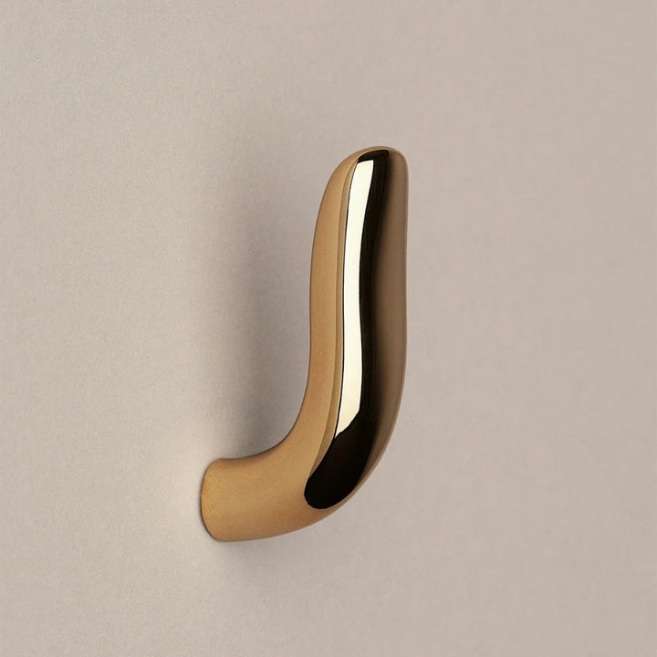 Softly curved J shaped hook in polished brass, side view.