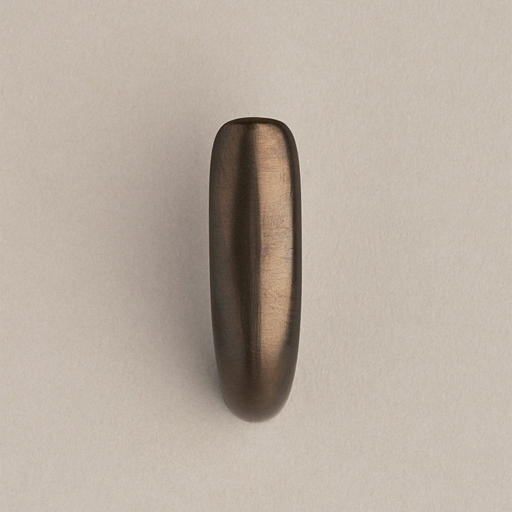 Softly curved J shaped hook in dark brass, front view.