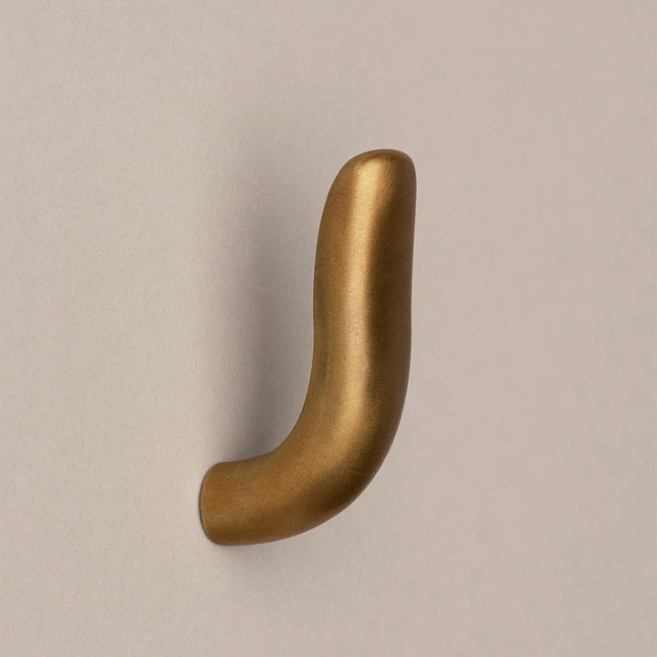 Softly curved J shaped hook in amber brass, side view.