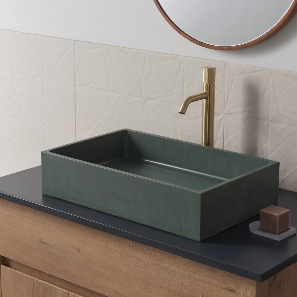 a mudd. concrete Jeker Basin sitting on top of a wooden counter.