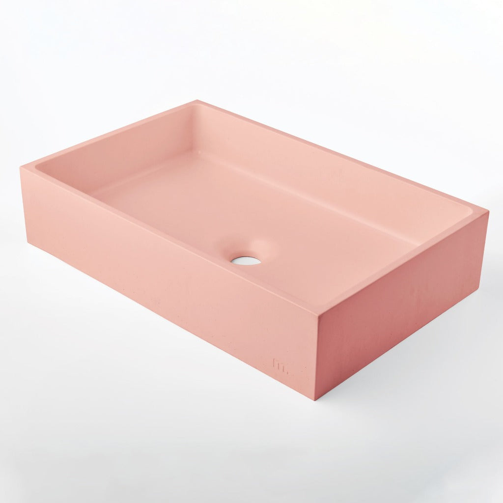 A pink rectangular Jeker Basin by mudd. concrete on a white background.