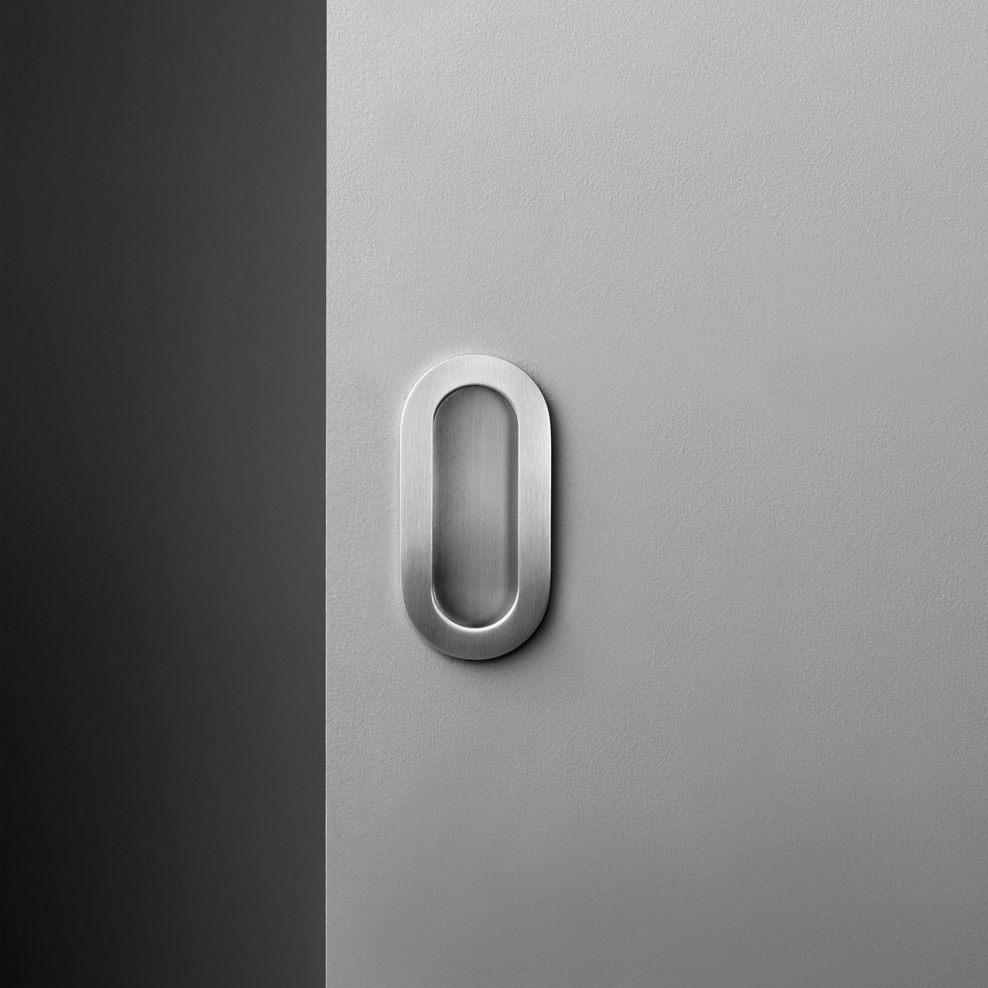 A white door with a d line Knud Oval Flush Pull on it.