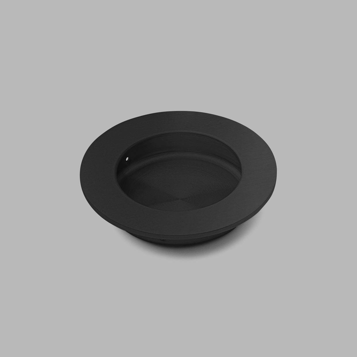 A black Knud Round Flush Pull from d line on a gray background.