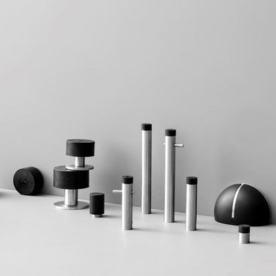 A group of d line Knud Wall Door Stops in black and white sitting on top of a table.